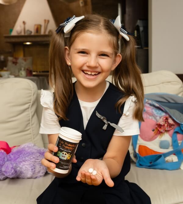 little girl holding bottle of intelligent labs children's live cultures and fibre