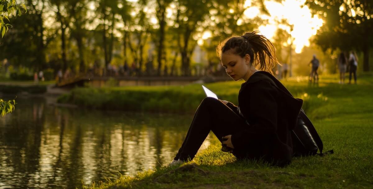 girl studying by the lake